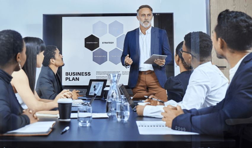 Business professionals discussing a strategy during a meeting with a presentation on business plan